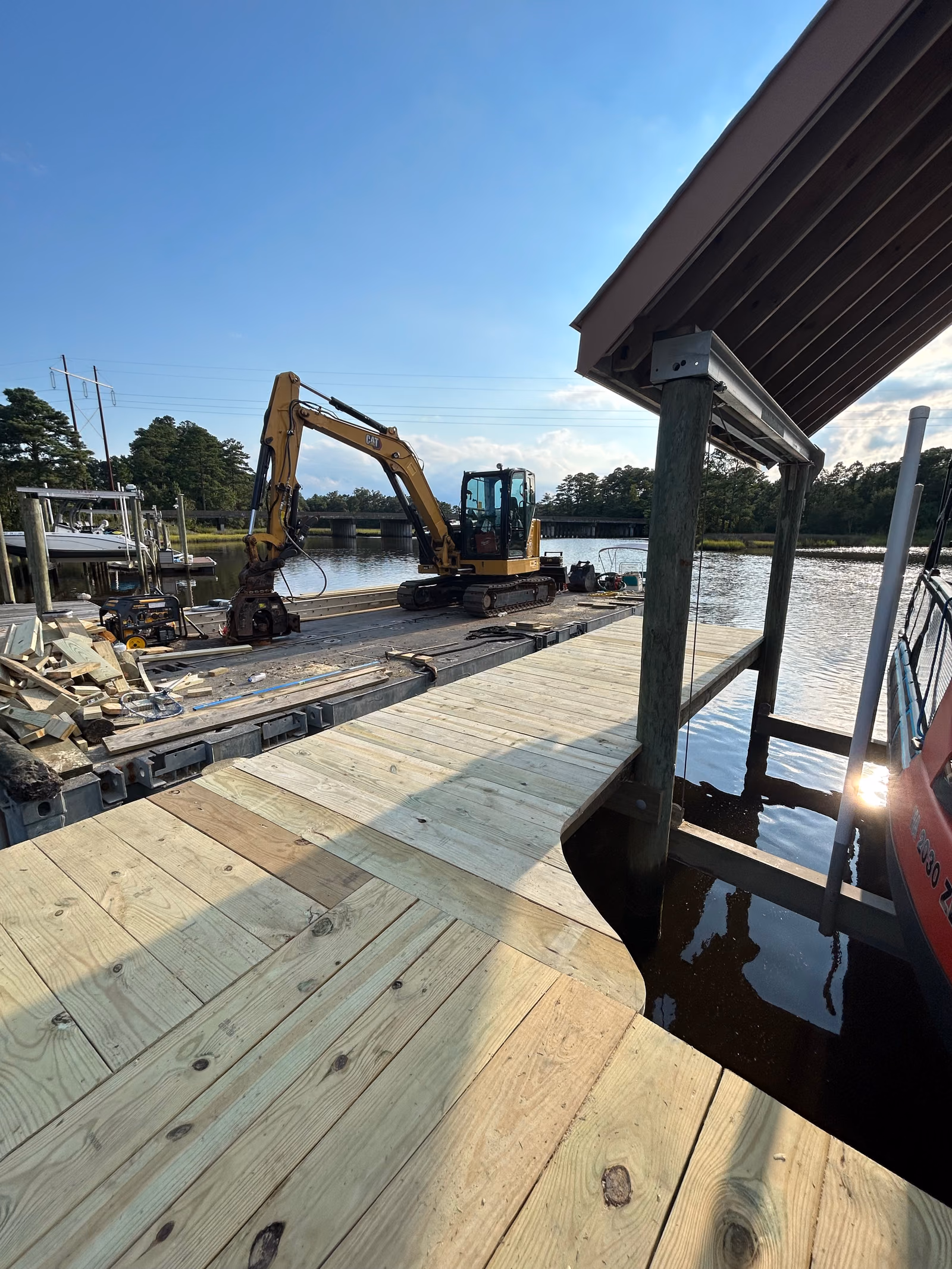 The Hanson excavator working from its deck barge alongside a new dock.