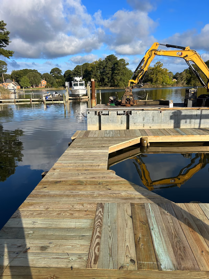 A new timber dock with the work barge and excavator just off the end.