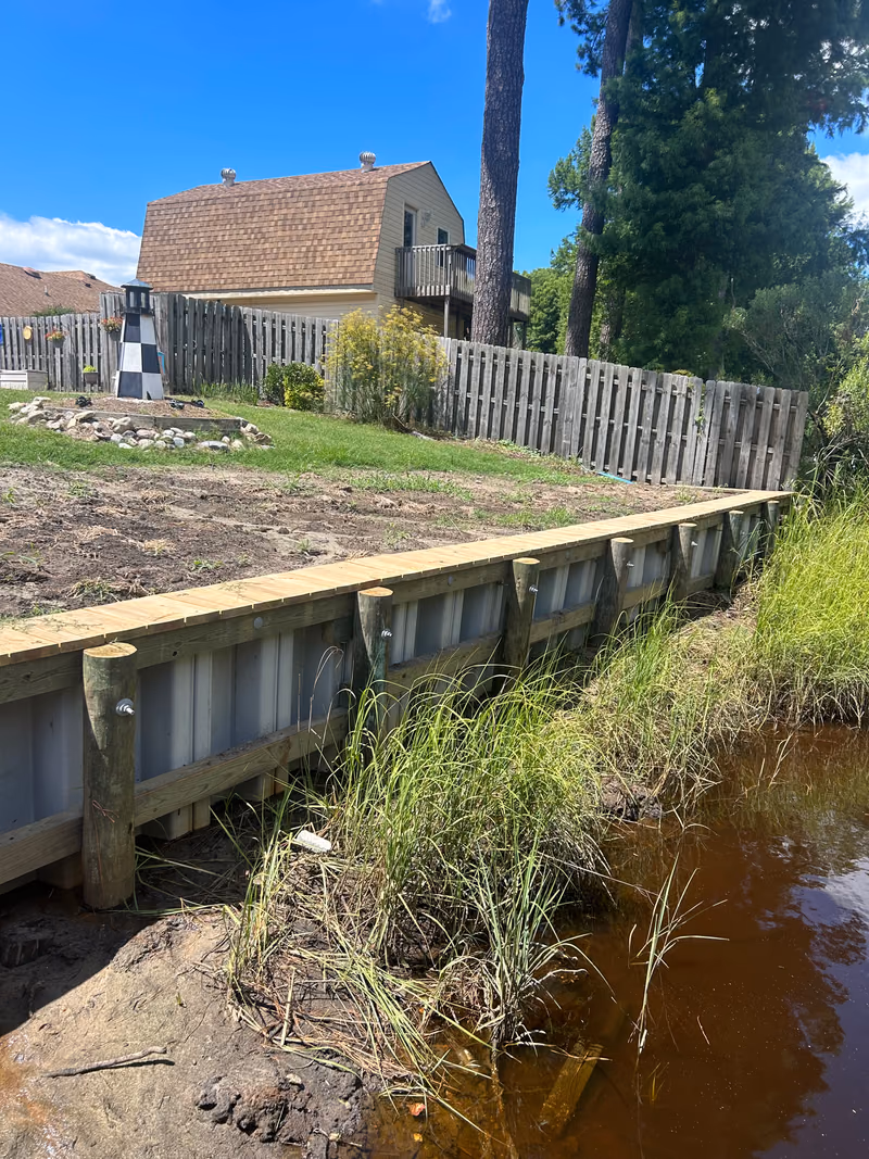 A vinyl bulkhead capped level with a regraded waterfront yard.
