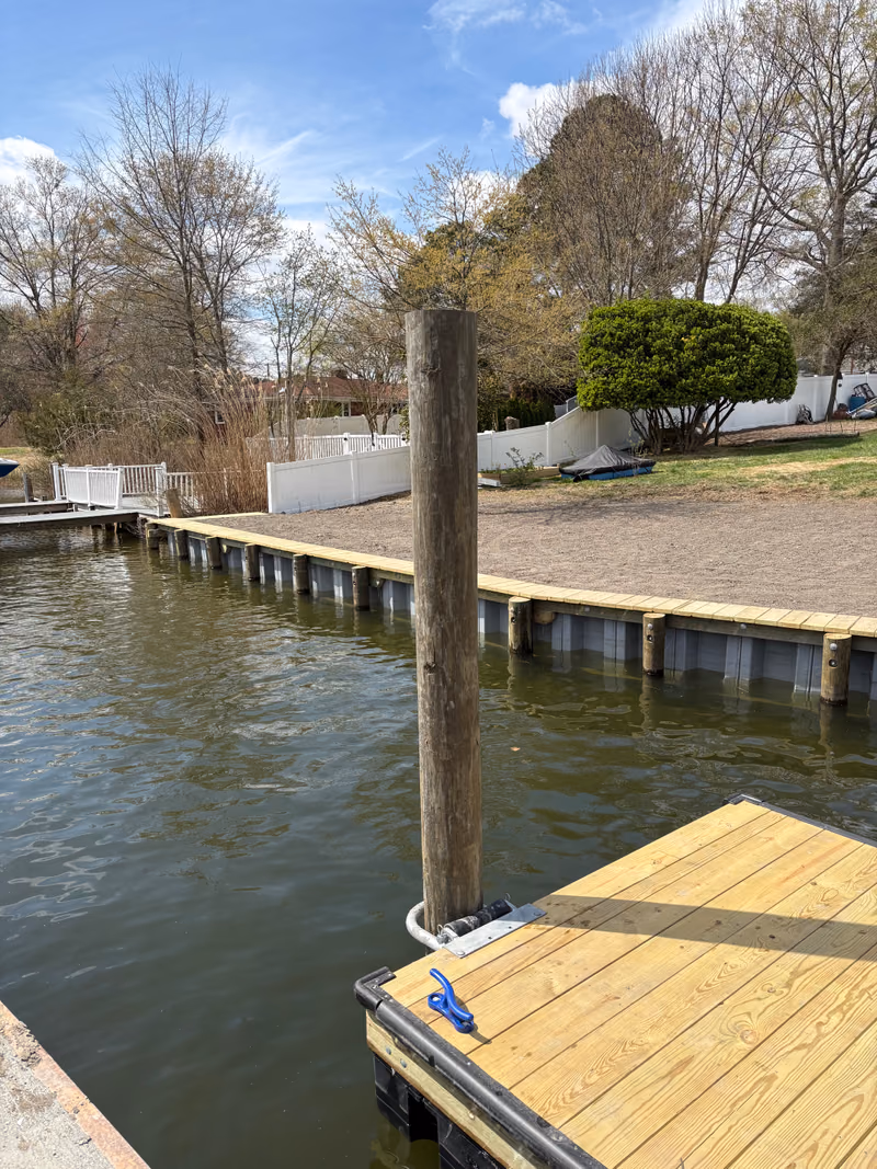A finished bulkhead holding back a graded yard, floating dock in the foreground.