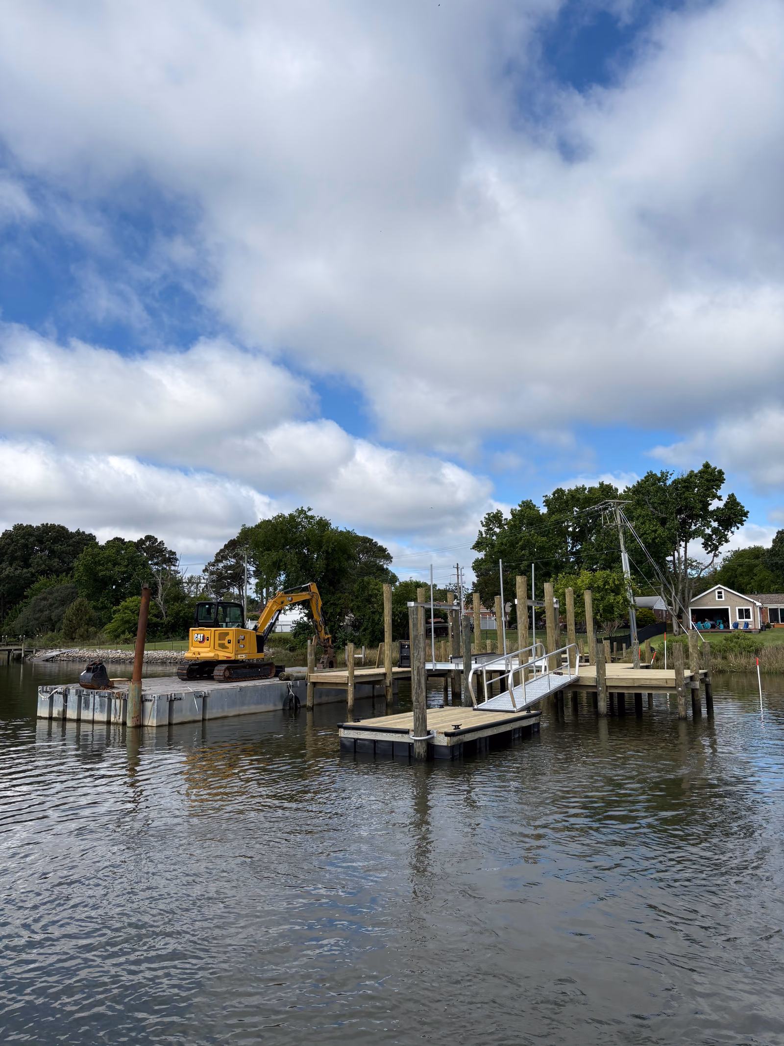 The Hanson crew setting pilings from the barge along a shoreline.