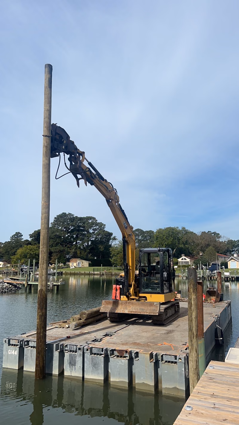 Pile driving from the barge: an excavator with a vibratory hammer on the boom.