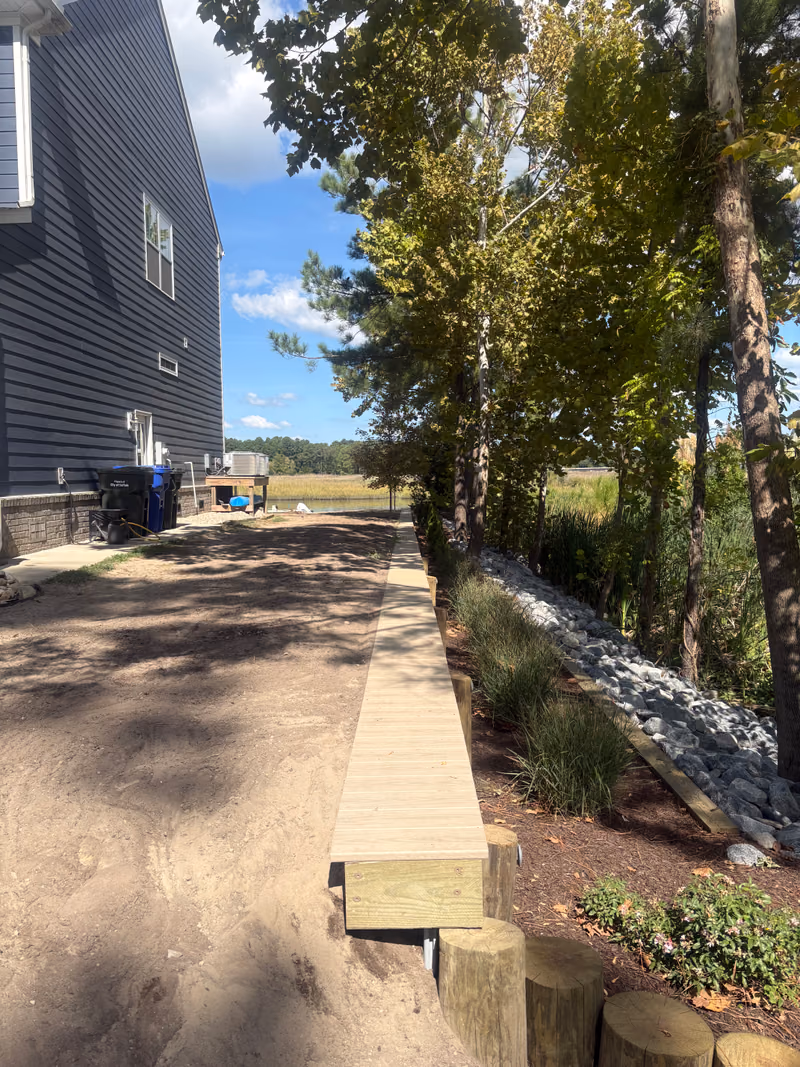 Timber steps and a walkway running down to a floating dock and boat lift.