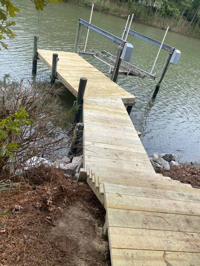 An aluminium gangway with handrails running down to a floating dock.