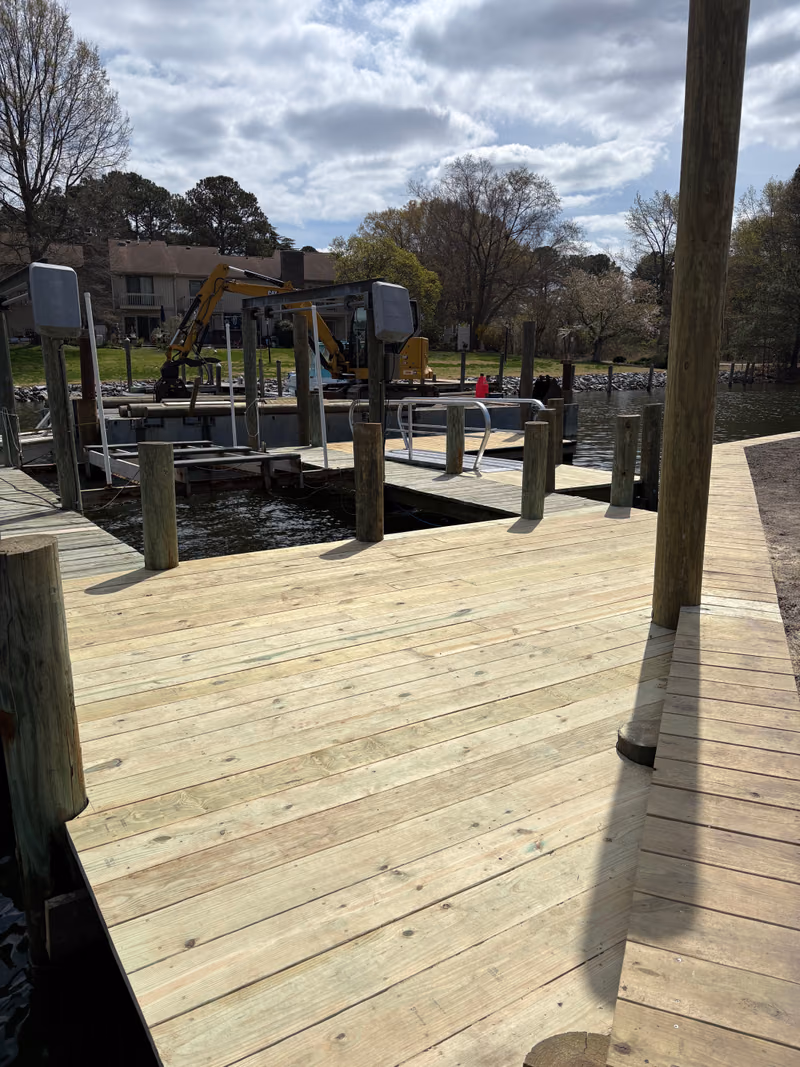 A broad new dock deck with boat lift motors mounted at the edge.