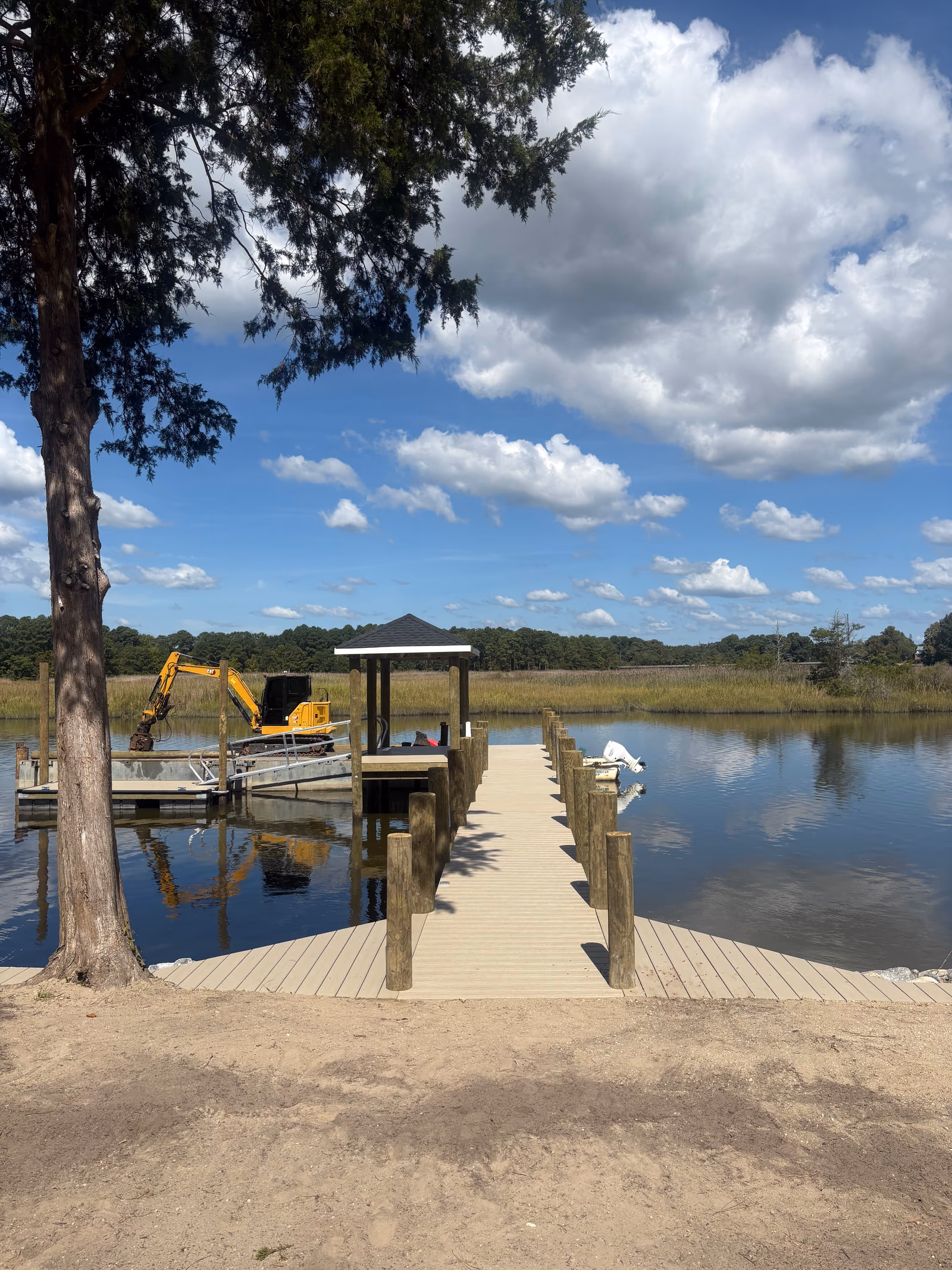 A composite-decked pier running out over marsh to a roofed gazebo.