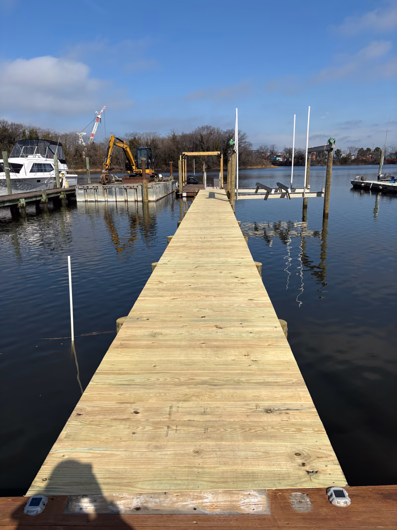 A wide Hanson dock, freshly decked, running out over calm water.